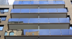 Tinted glass railing with stainless steel baluster and wood handrail