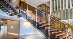 Tinted glass railing with stainless steel baluster and wood handrail