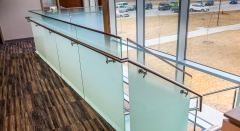 Frosted glass standoff glass railing with side mounted steel handtail