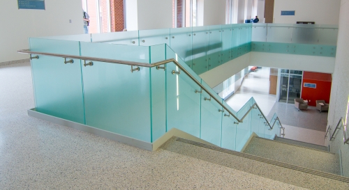 Frosted glass standoff glass railing with side mounted steel handtail