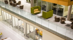 Standoff glass railing with stainless steel handrail for commercial