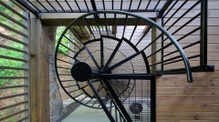 Steel black spiral staircase with contemporary grid plate stair treads