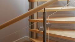 Helical spiral staircase in solid wood with glass railing