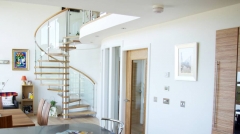 Helical spiral staircase in solid wood with glass railing