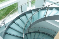 Modern commercial curved staircase with frosted glass tread and glass railing