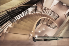 Modern open riser curved spiral staircase with steel rod railings