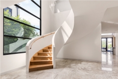 Modern freestanding wood curved stairway with closed riser