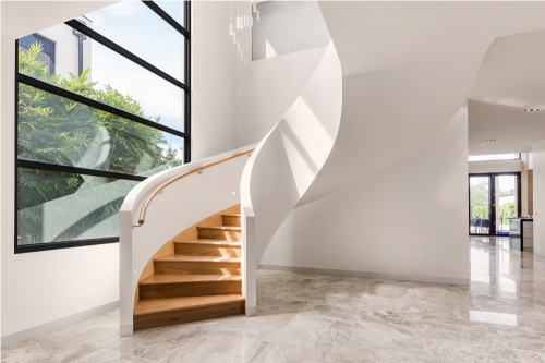 Modern freestanding wood curved stairway with closed riser