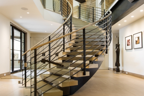Modern open riser curved spiral staircase with steel rod railings