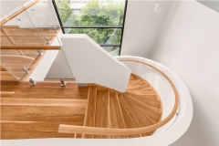 Modern freestanding wood curved stairway with closed riser