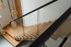 Central stringer stairs with glass railing and steel handrail