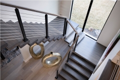 Mono stringer staircase with dark wood tread and cable railing