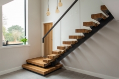 Central stringer stairs with glass railing and steel handrail