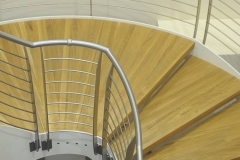 Double staircase with steel rod railing and curved middle landing