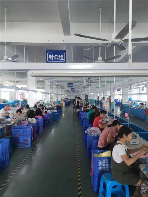 Ci sono centinaia di lavoratori nella fabbrica di borse di tela stampata