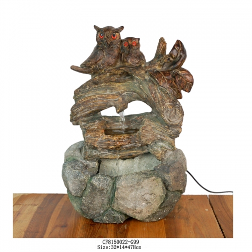 Resin owl fountain standing on a tree trunk