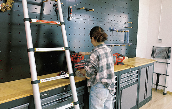 A girl is sorting out her hardware tools with a soft close telescopic ladder nearby