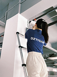 a girl is standing on a telescoping ladder and she is installing a camera