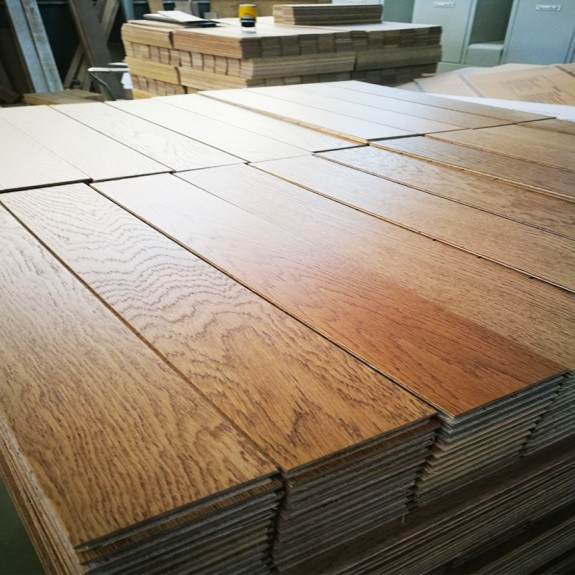 UV-cured natural wood flooring planks with scratch-resistant finish, bulk production stock