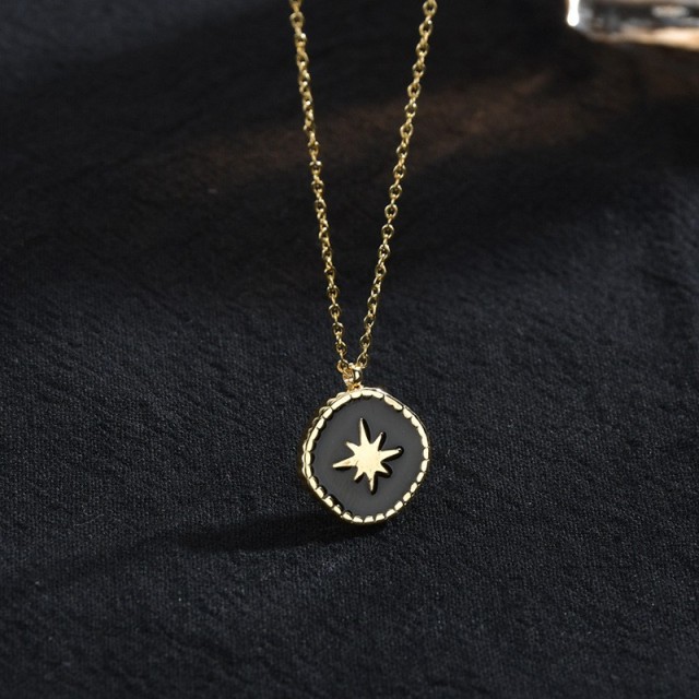 Gold and black resin starburst medallion necklace in stainless steel
