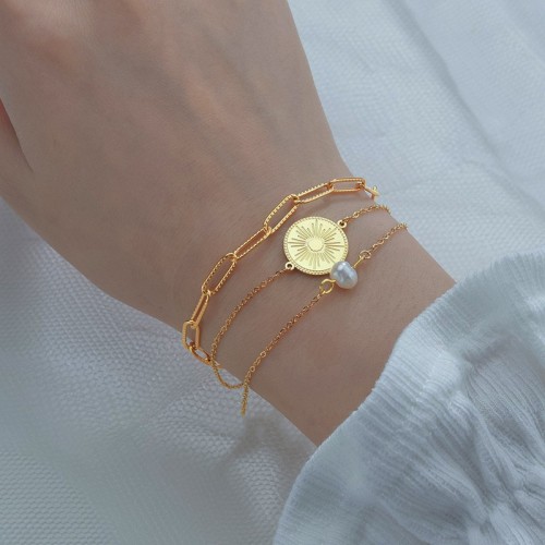 Triple layered chain bracelet with sunburst medallion and pearl