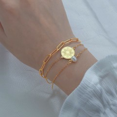 Triple layered chain bracelet with sunburst medallion and pearl