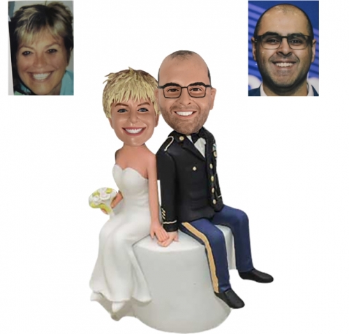 Custom wedding bobbleheads cake toppers sitting on cake