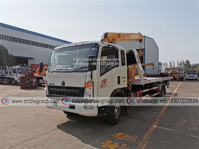 HOWO RHD 5 ton tilt tray truck roll back towing a car with a truck wrecker