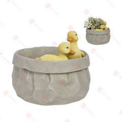 RESIN DUCKLINGS SITTING IN PAPER BAG PLANTER