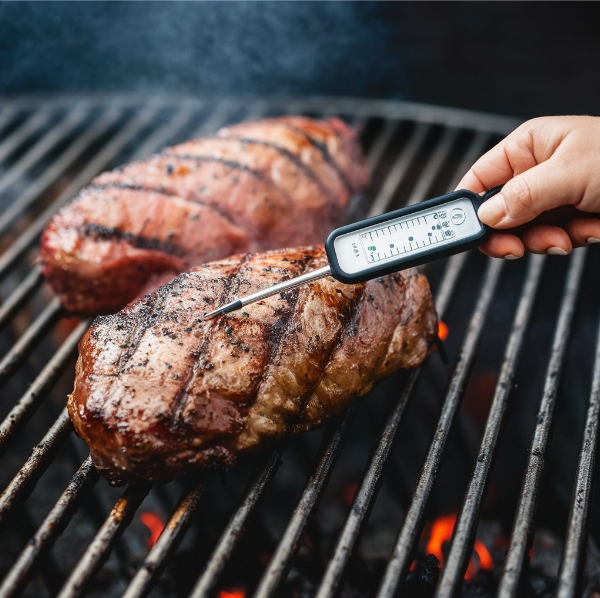 Checking the burger patty’s internal temperature with a meat thermometer when cooking
