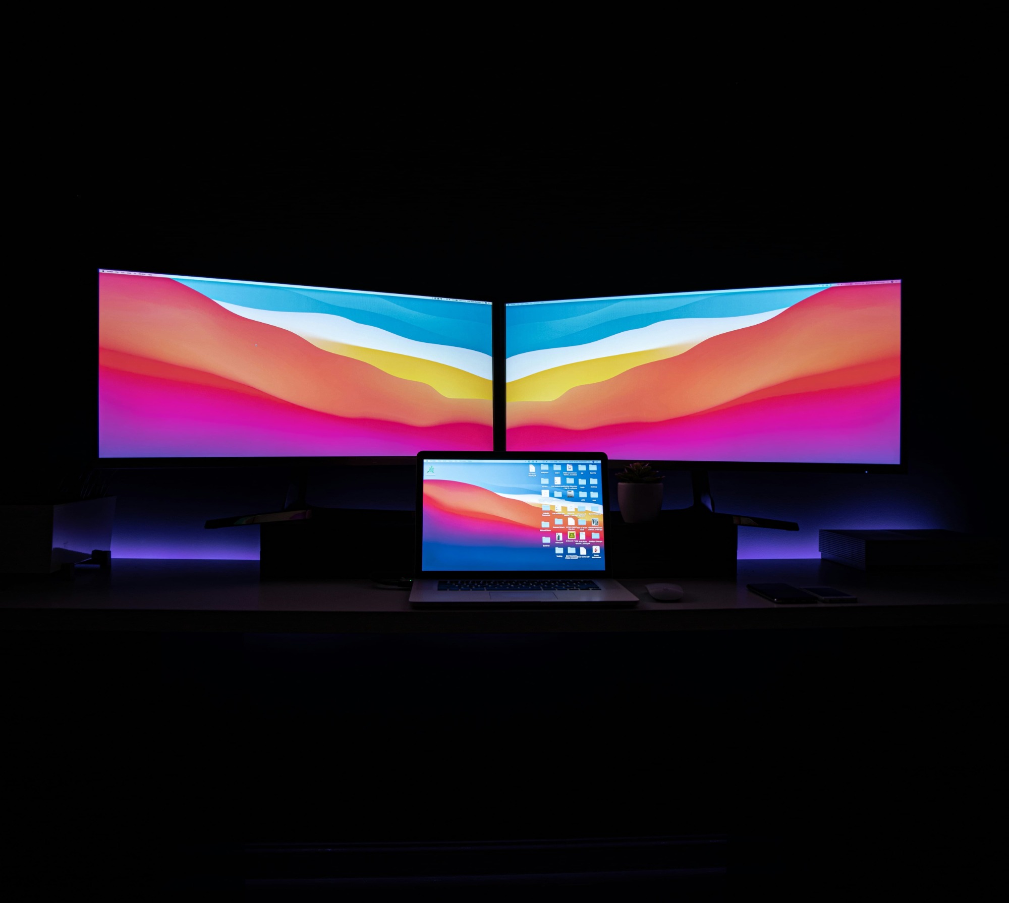 A laptop computer has a 4K display and an 8K display behind it.