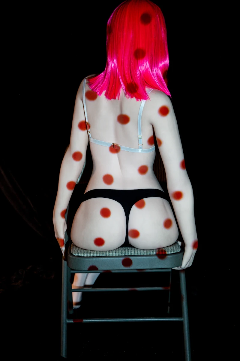 alluring-sex-doll-plloy-sitting-on-chair-back-view