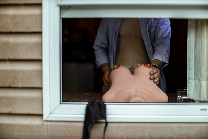 Female-sex-doll-torso-157-black-lying-by-window
