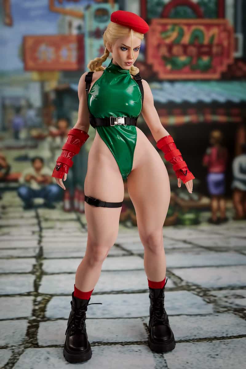 Wearing her classic green leotard and a signature red beret, this anime sex doll stands tall in an iconic pose against a bustling urban backdrop, exuding powerful visual charisma.