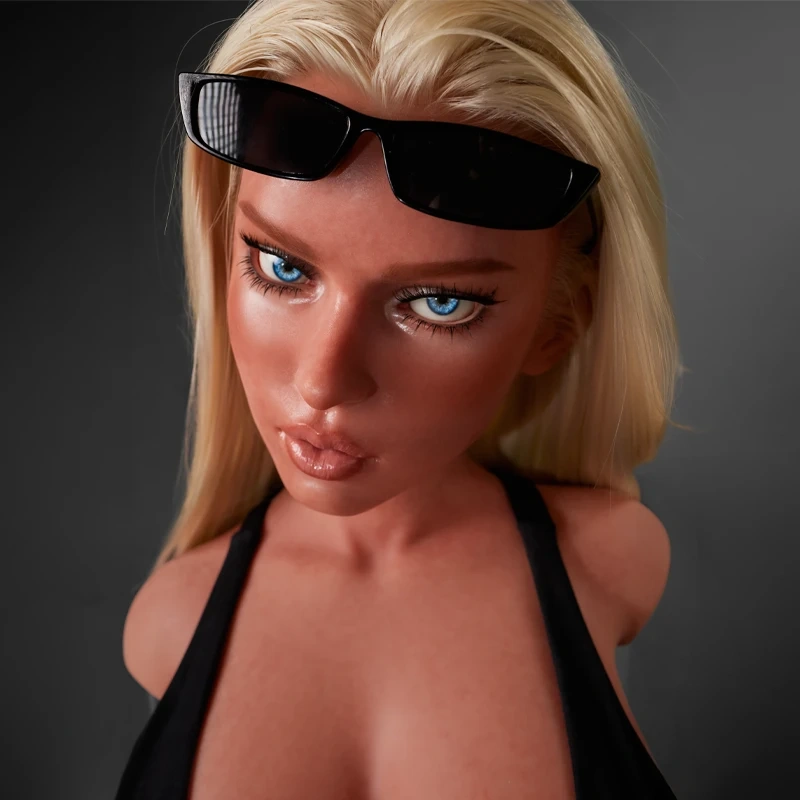 ULW 883# Fiora: This close-up shot showcases the intricate face of the doll with long blonde hair, pushing black sunglasses up onto her forehead, featuring vivid blue eyes with defined makeup and glossy lips over a smooth, lifelike skin texture.