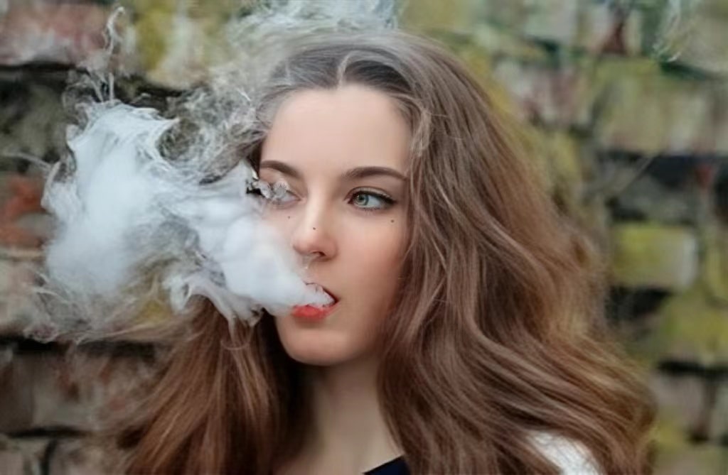 a beautiful girl is vaping with MTL disposable vape