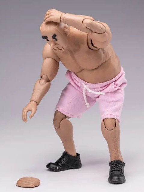 Notaman action figure is picking up the wig that has fallen from the ground.