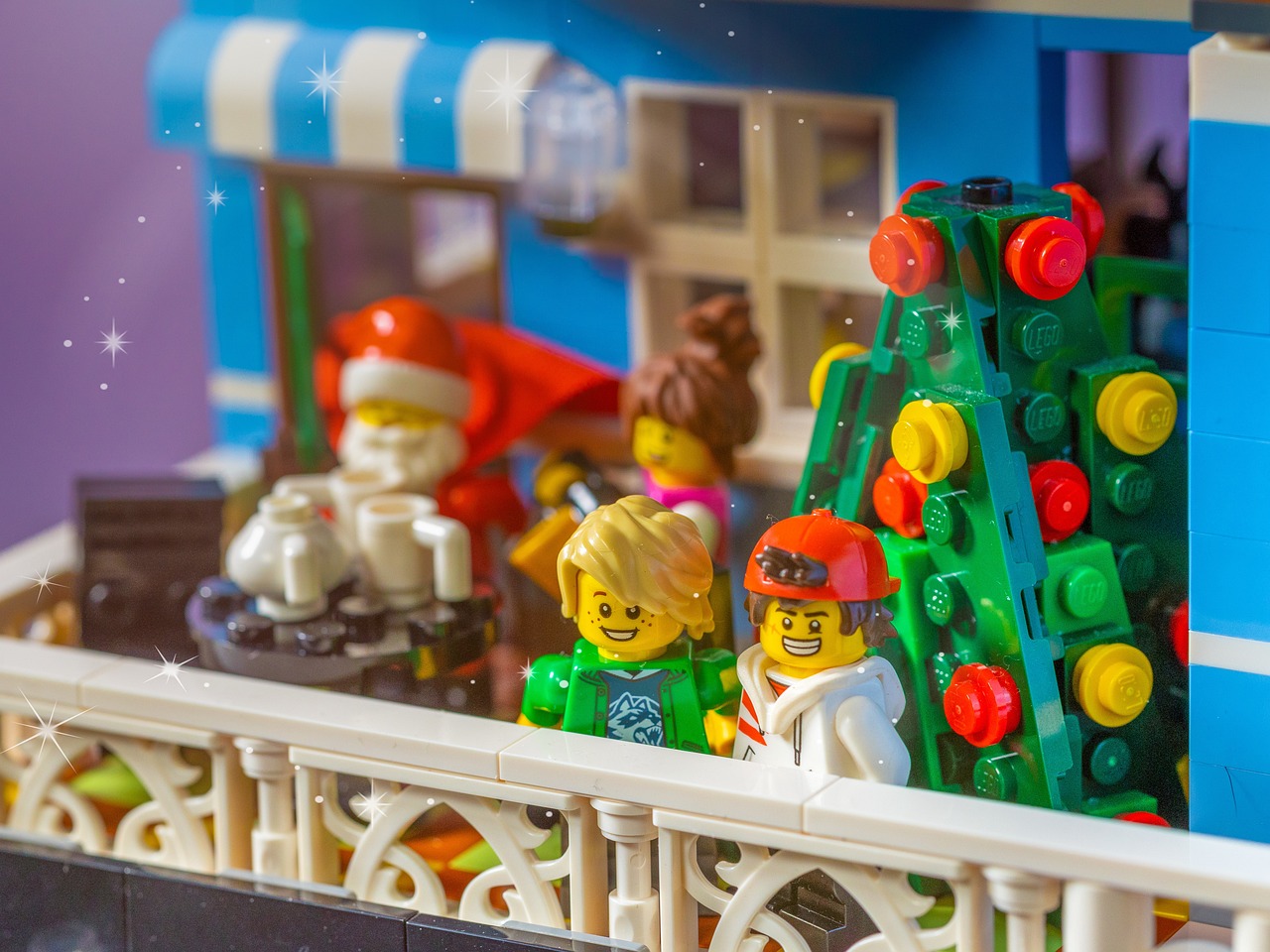 Two dolls were looking outside at the railing. Behind them were Santa Claus and the Christmas tree, filled with the atmosphere of Christmas.