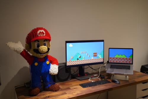 Mario blocks are standing on the table, with the background of the Mario game beside them.