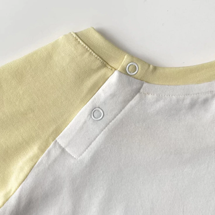 Close-up of nickel-free snaps on plant-dyed baby bodysuit