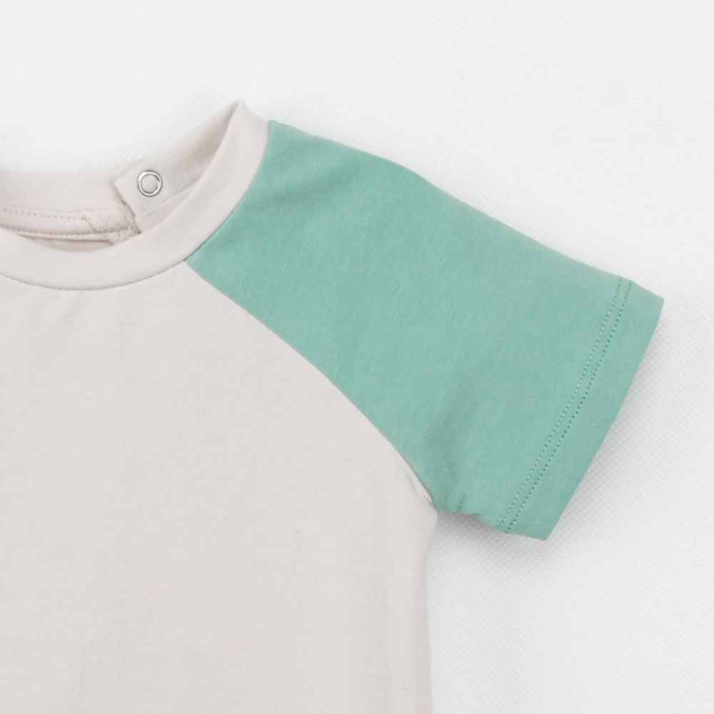 Neck and shoulder close-up of Raglan organic-cotton baby tee with plant-dyed color (botanical dye)