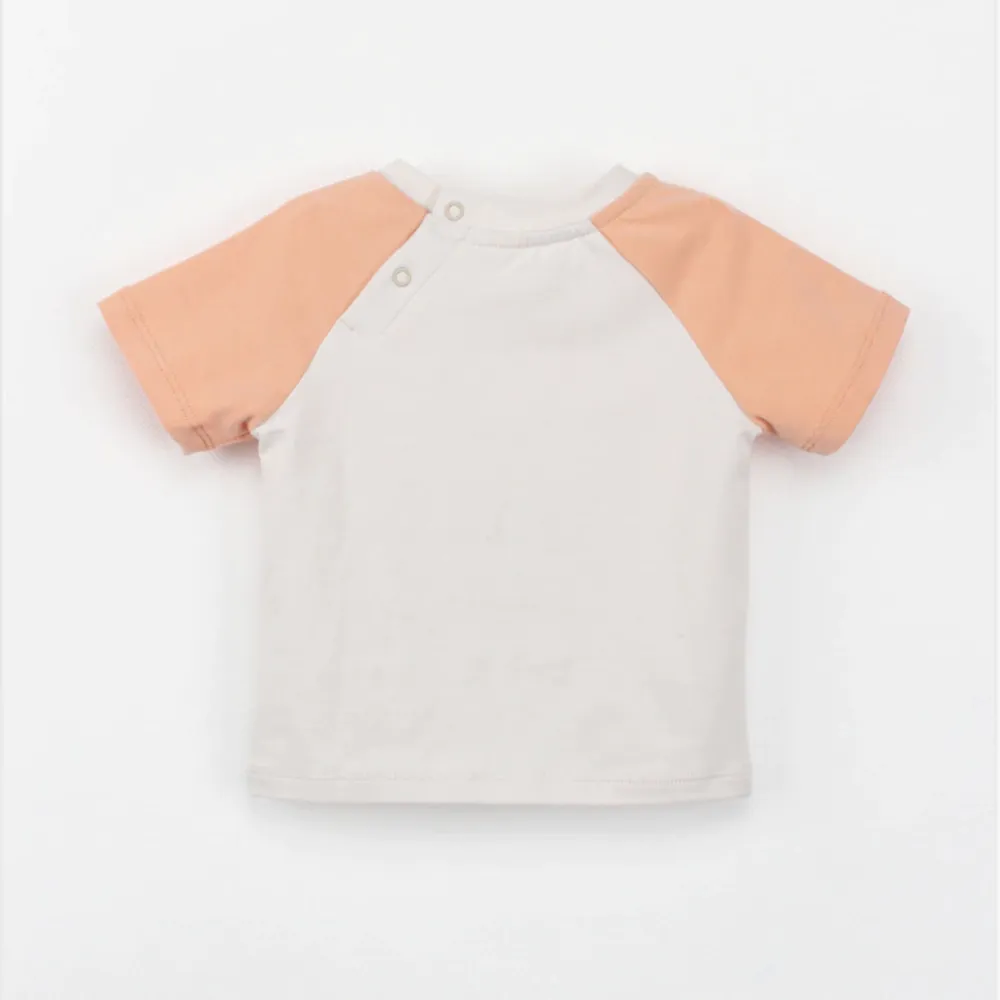 Back view of SENSENG unisex baby Leo raglan short sleeve tee in plant-dyed botanical natural powder puff and coral colorway, showing the sporty contrast shoulder layout