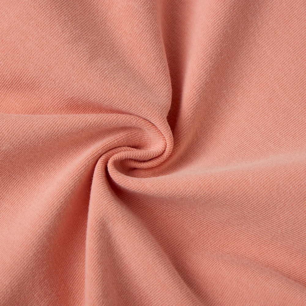 Close-up of fabric on organic pumpkin baby bodysuit and hat set made with plant-dyed organic cotton