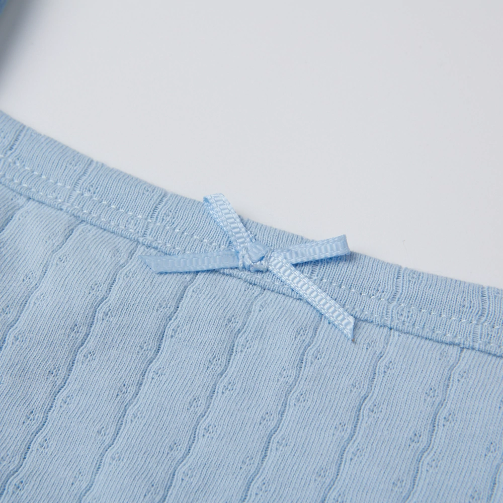 Baby girl wearing Senseng organic cotton pointelle strappy bodysuit, plant-dyed, breathable and eco-friendly