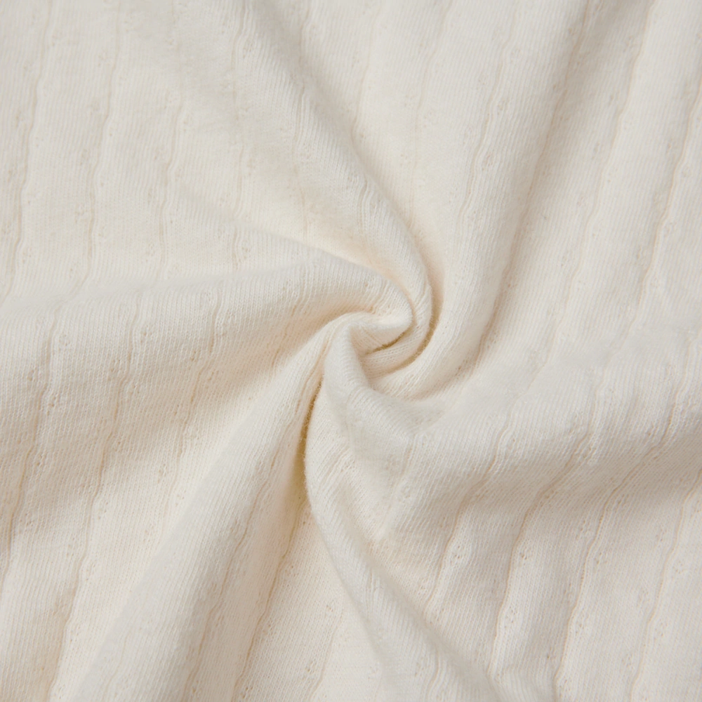 Baby girl wearing Senseng organic cotton pointelle strappy bodysuit, plant-dyed, breathable and eco-friendly