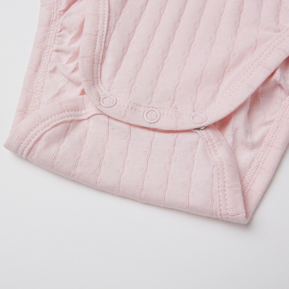 Baby girl wearing Senseng organic cotton pointelle strappy bodysuit, plant-dyed, breathable and eco-friendly