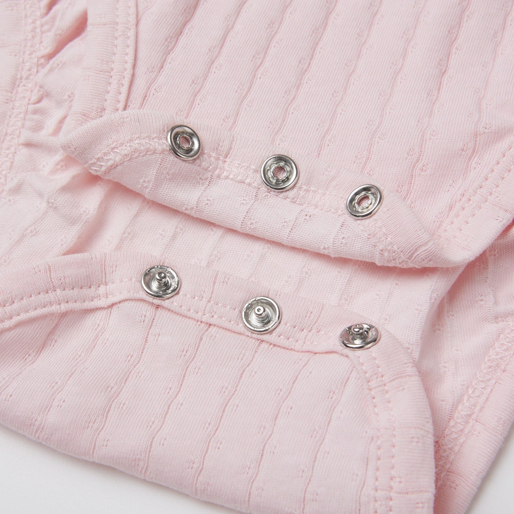 Baby girl wearing Senseng organic cotton pointelle strappy bodysuit, plant-dyed, breathable and eco-friendly