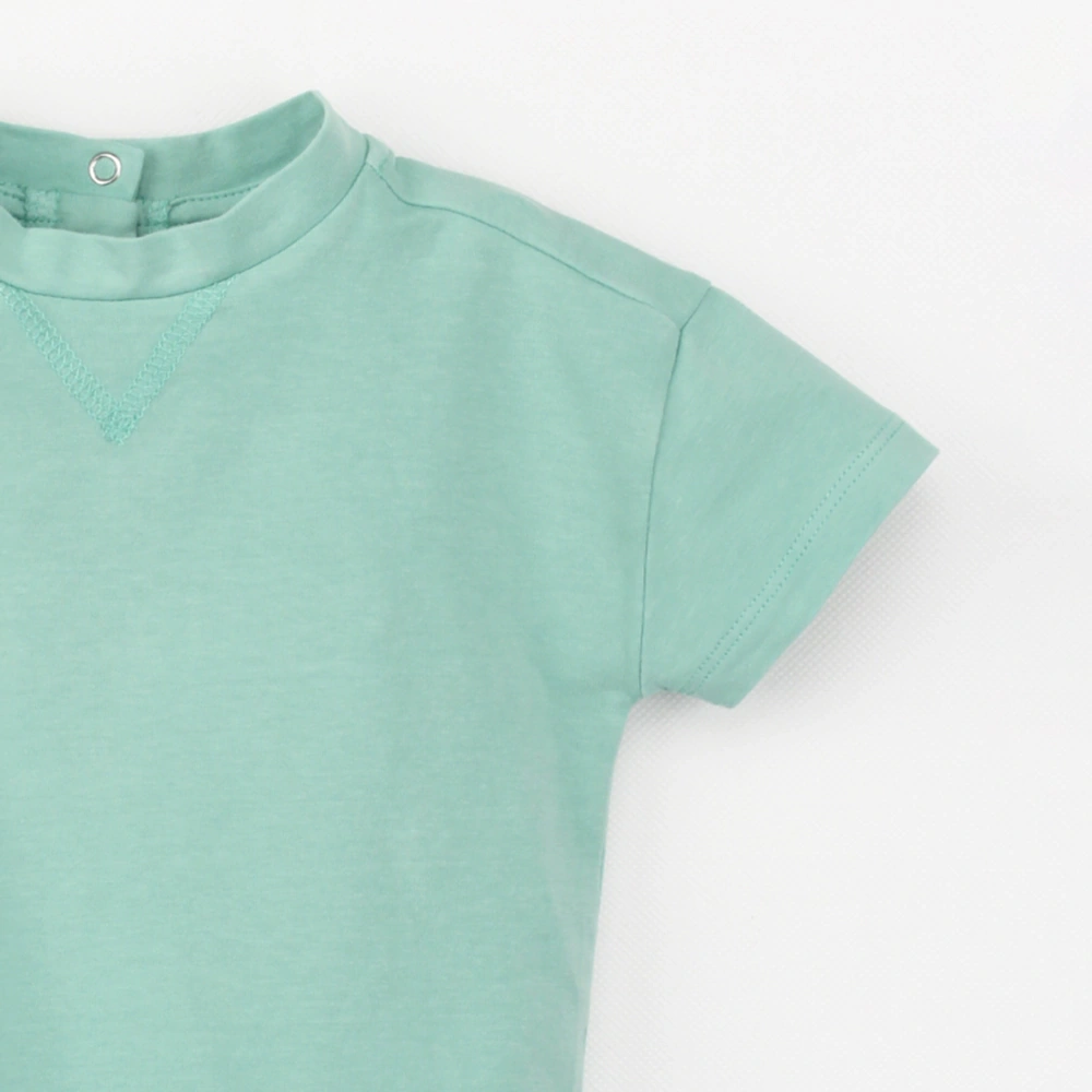 Close up of of plant-dyed organic-cotton drop-shoulder baby bodysuit with snap closure (K1230822)