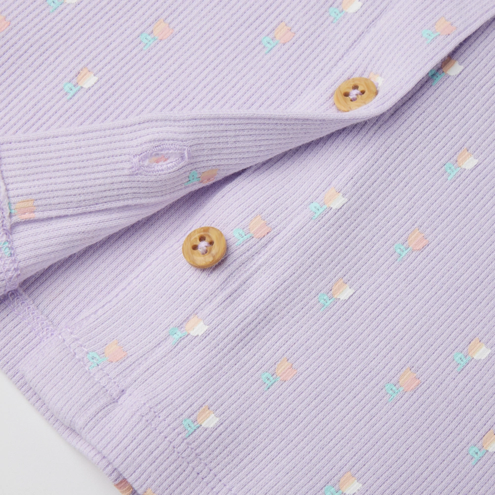 close up of front on girl long sleeve ribbed button-up top and pants set made from organic cotton with natural plant dyes