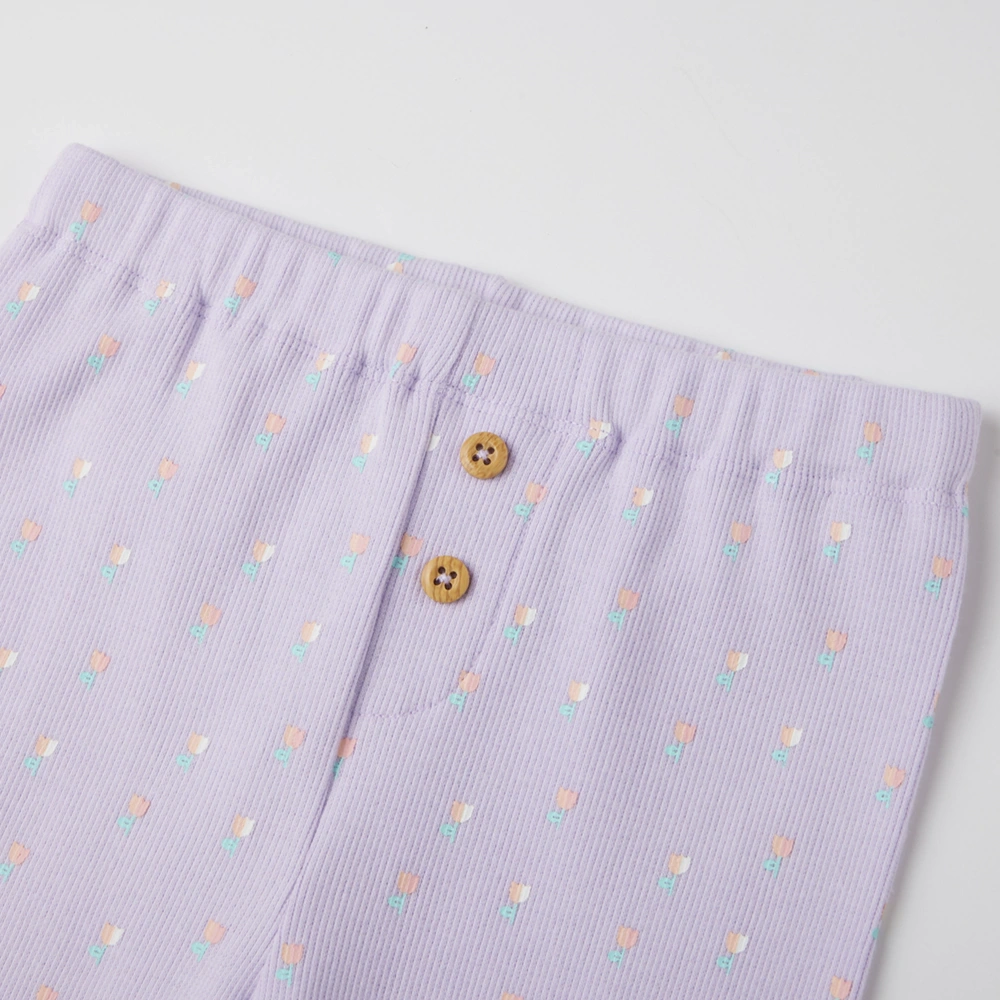 close up of front on girl long sleeve ribbed button-up top and pants set made from organic cotton with natural plant dyes